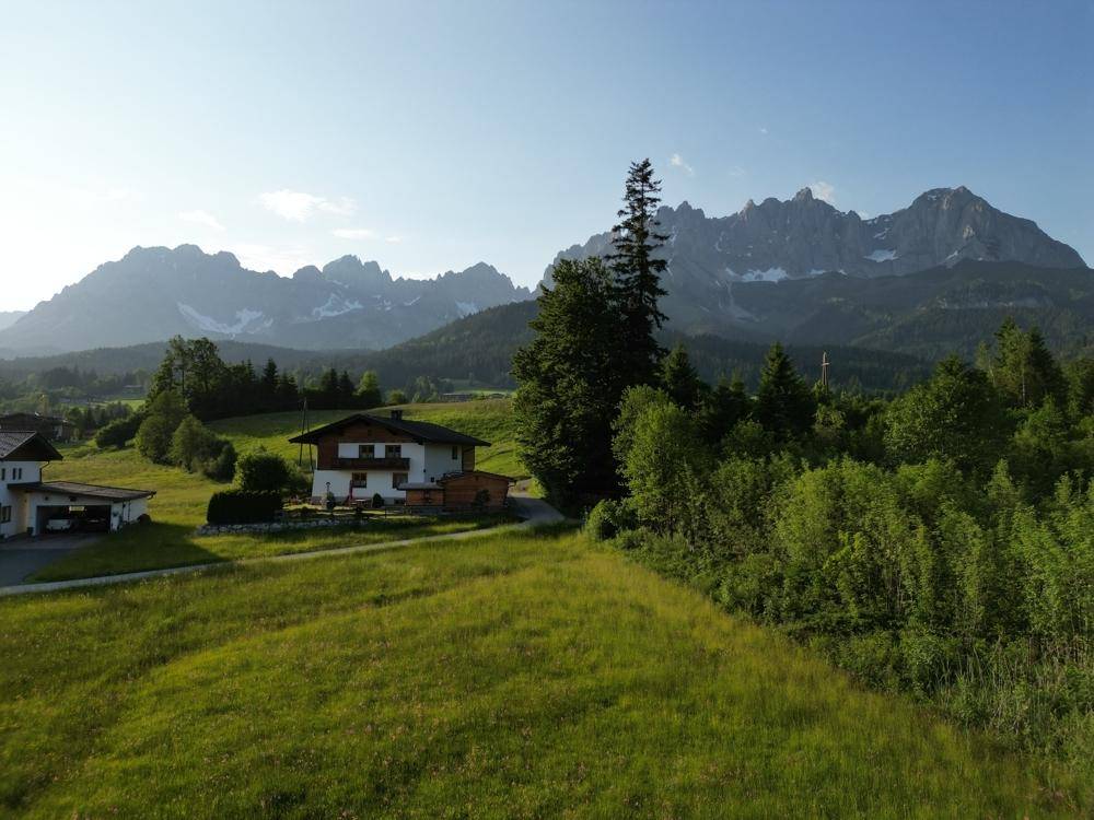Haus im Chalet-Stil in ländlicher Umgebung mit beeindruckendem Bergblick und grünen Wiesen.