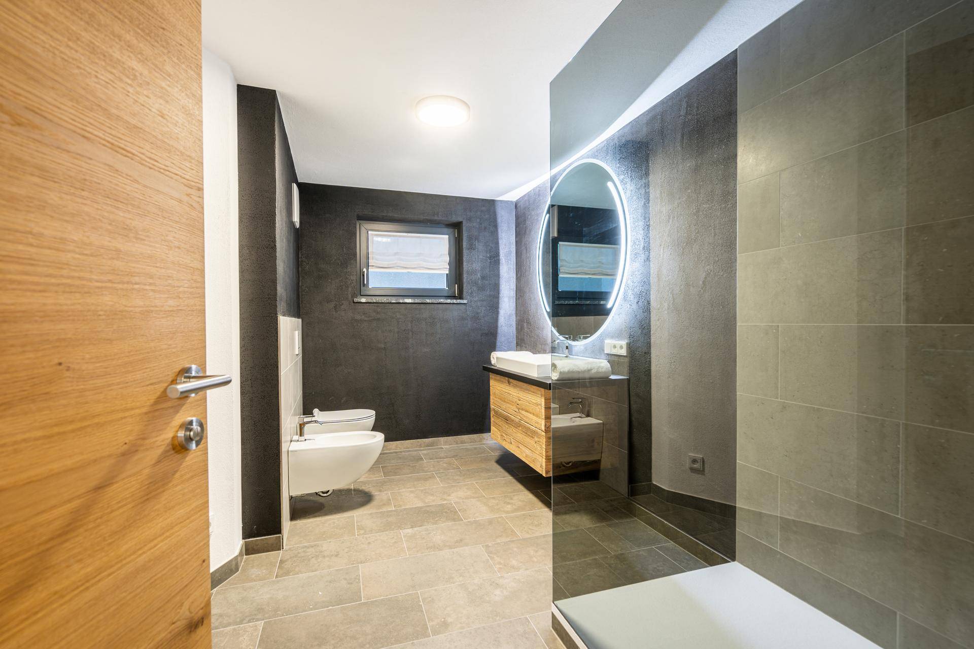 Stilvolles Badezimmer mit modernem Waschtisch, Bidet und großer Spiegelfläche.