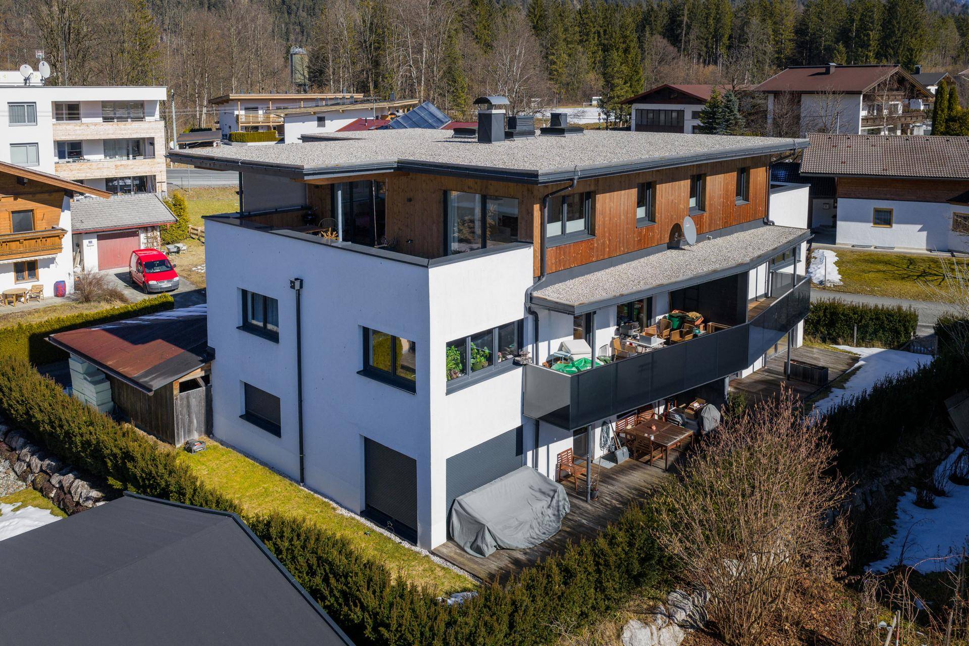Ansicht der modernen Wohnanlage mit großzügigen Balkonen und Terrassen in einer Berglandschaft.