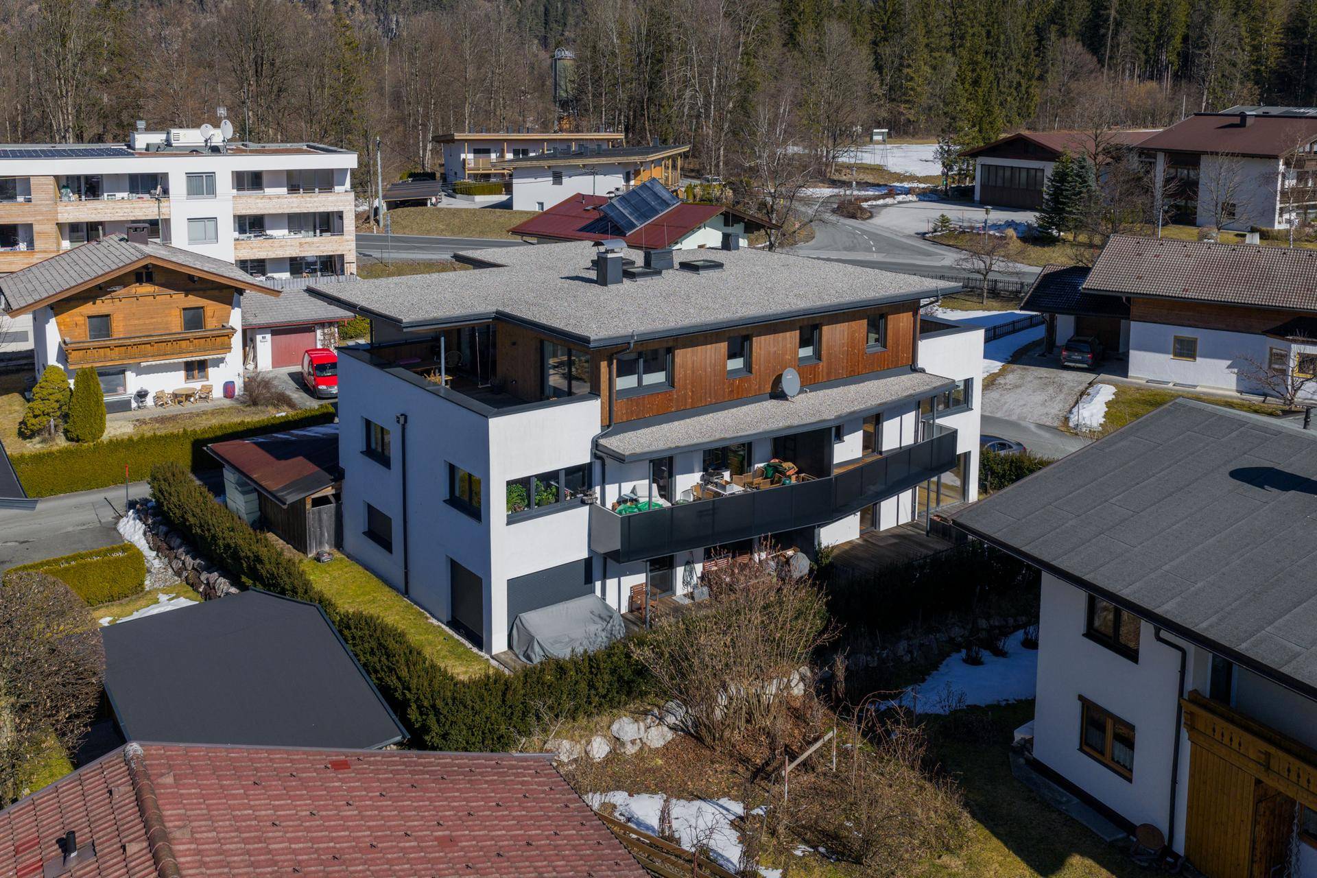 Vogelperspektive der modernen Wohnanlage mit Holzelementen und Flachdach in einer ländlichen Umgebung.