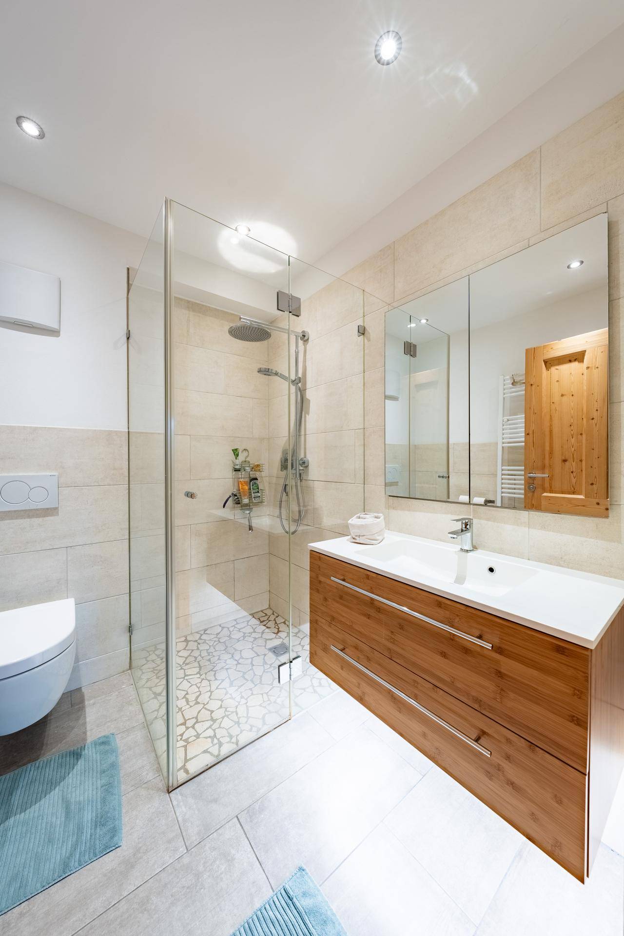 Modernes Badezimmer mit ebenerdiger Dusche, Einzelwaschbecken und Wand-WC.