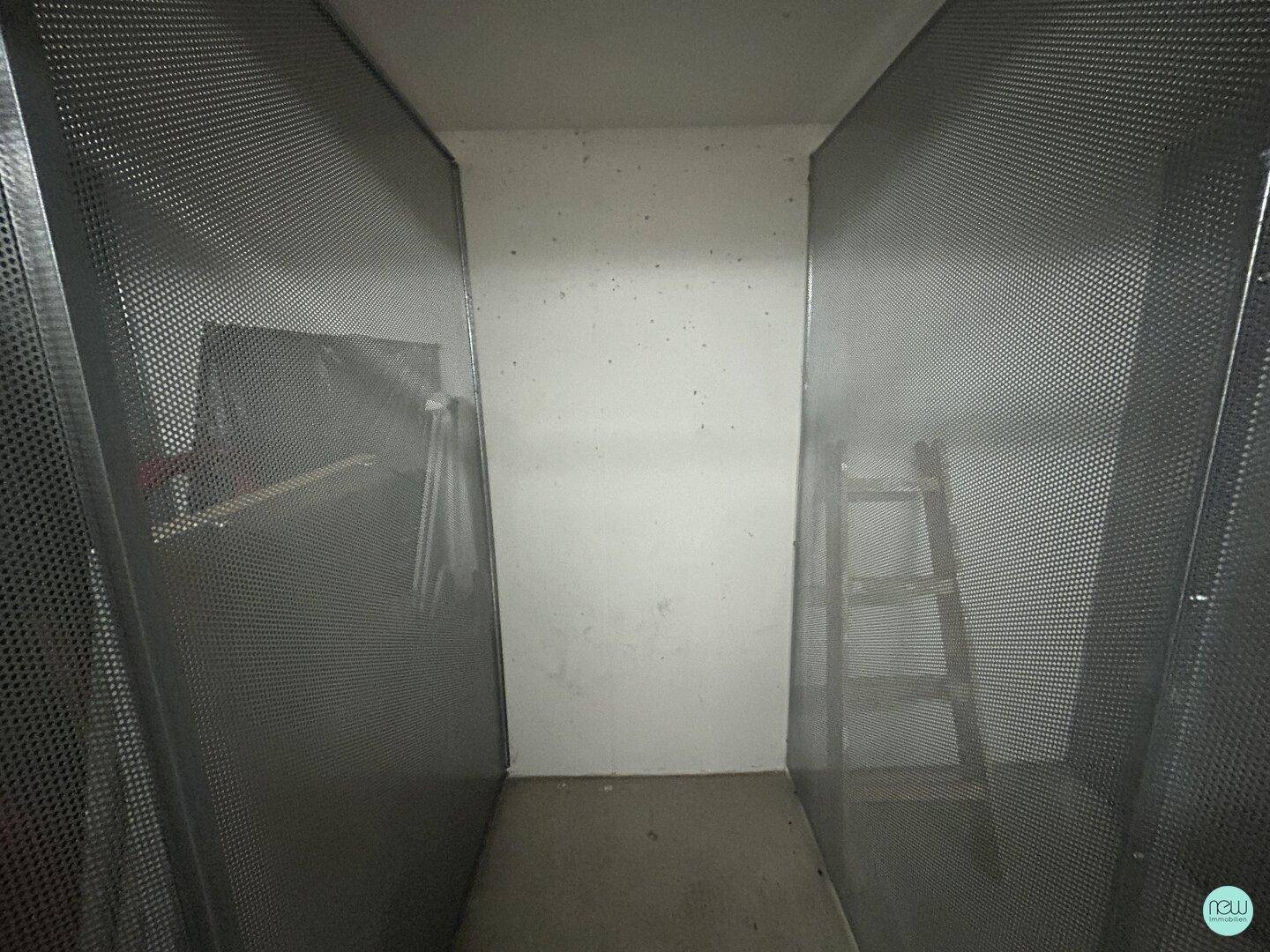 Einfacher Abstellraum mit Metallgittern und einer Leiter, ideal für zusätzlichen Stauraum.