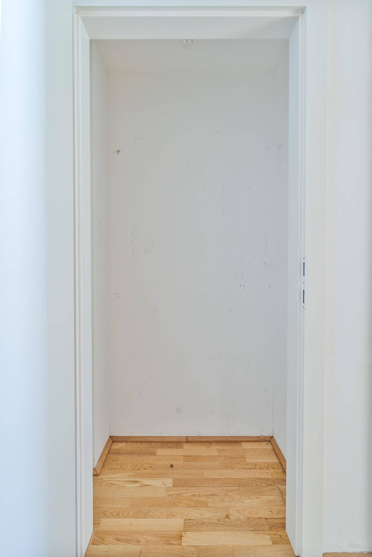 Leerer Nischenbereich mit Parkettboden, ideal als Abstellraum oder Garderobe nutzbar.