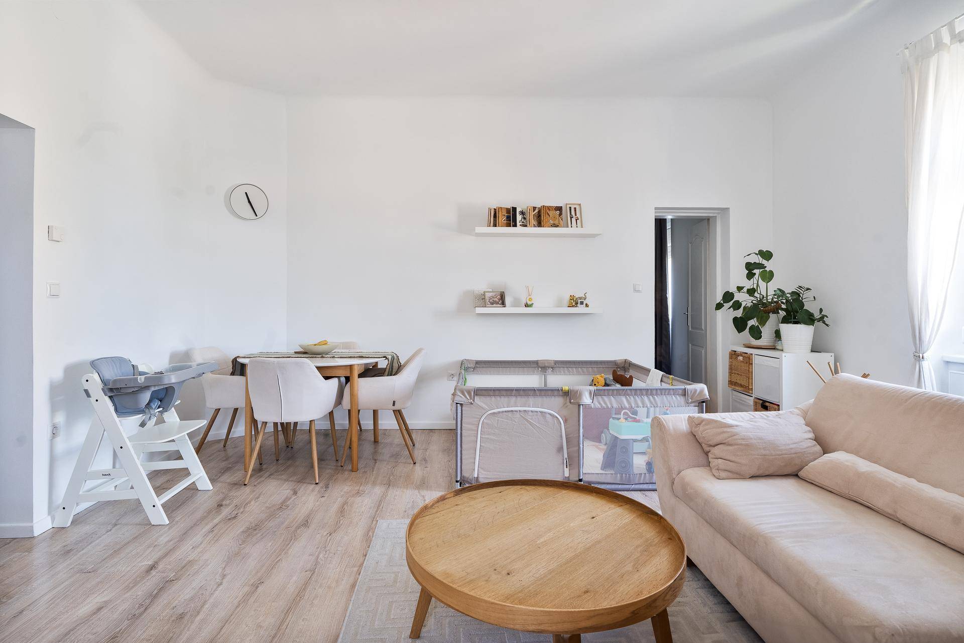 Offener Wohn- und Essbereich mit Holzboden, Esstisch und gemütlichem Sofa.