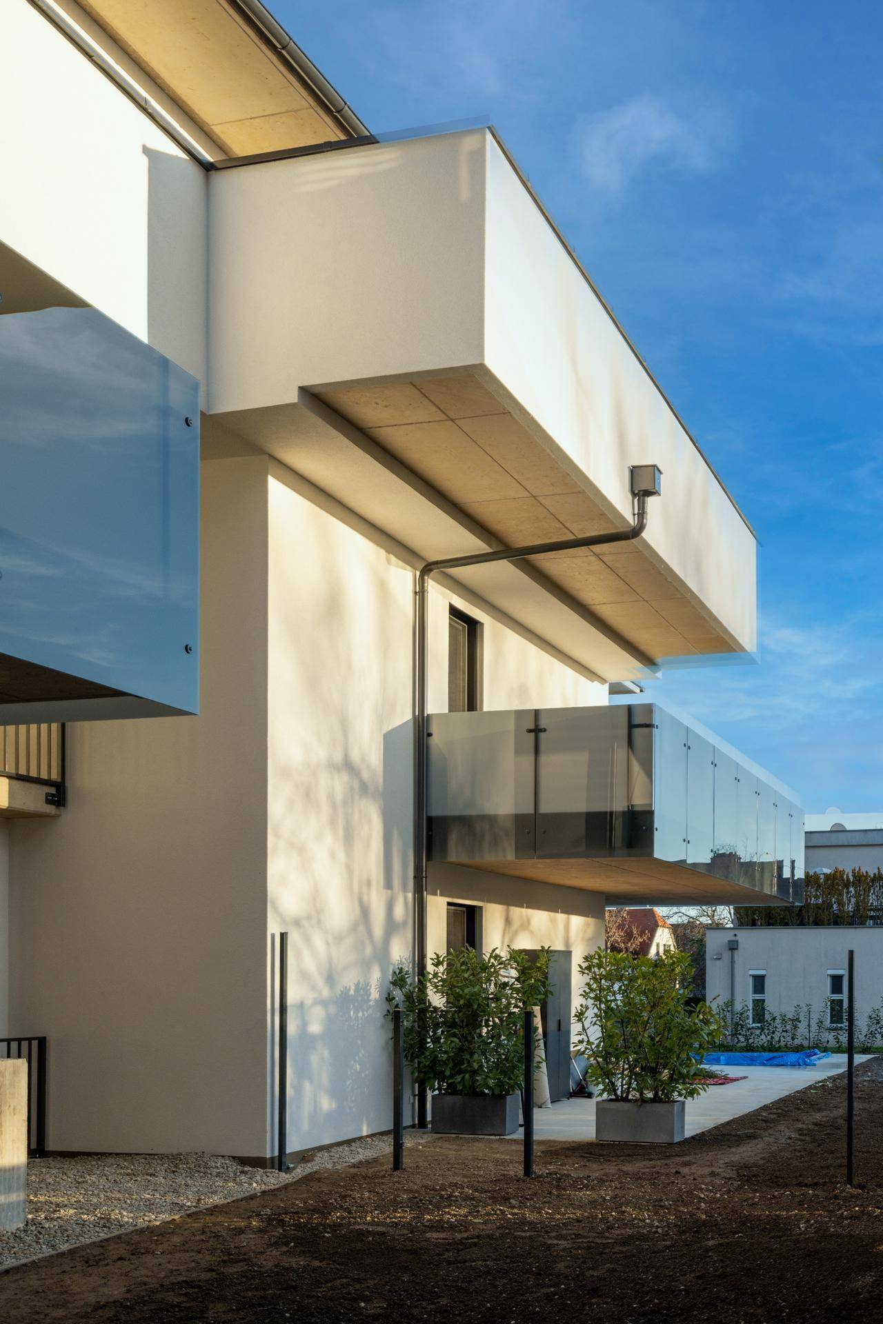 Detailansicht der modernen Fassade mit auskragenden Balkonen und Glasgeländern.