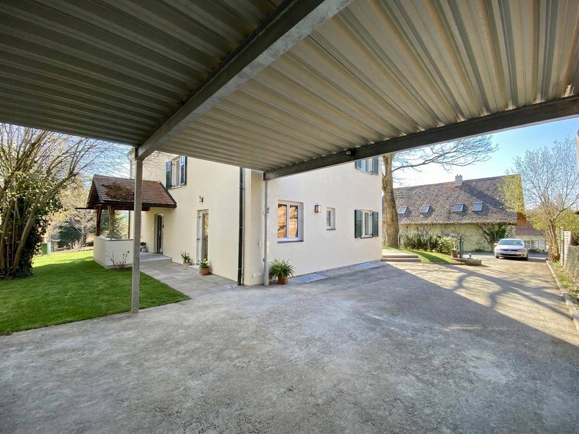 Geräumiger Carport und Zufahrt zum Haus, bietet geschützten Parkplatz für Fahrzeuge.