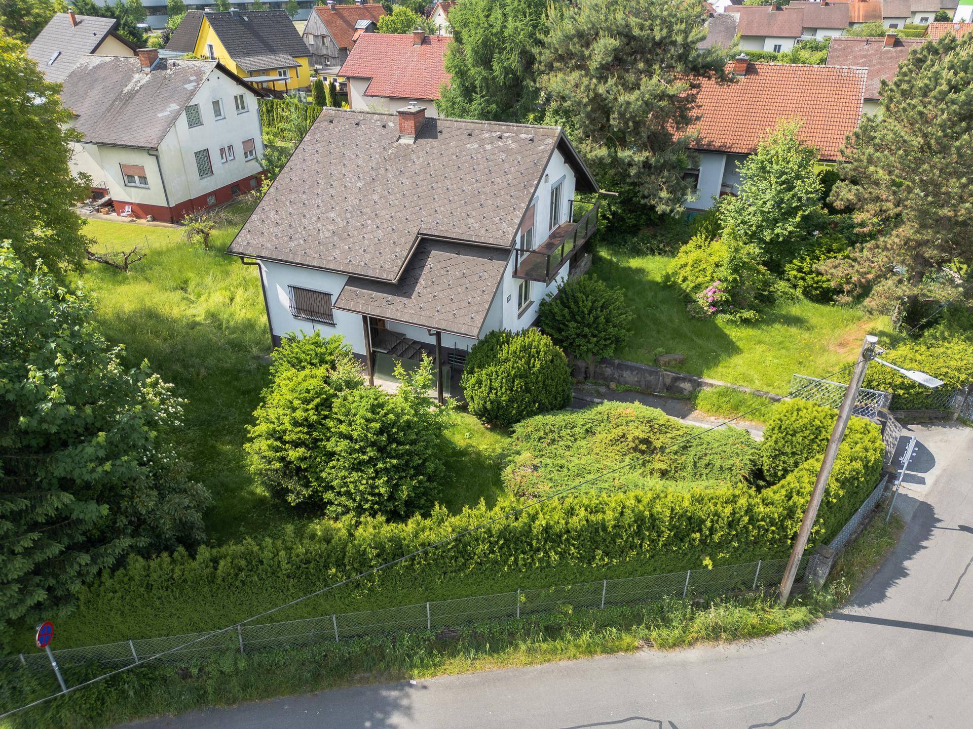 Vogelperspektive des Einfamilienhauses mit Garten und Blick auf die umliegende Wohnsiedlung.
