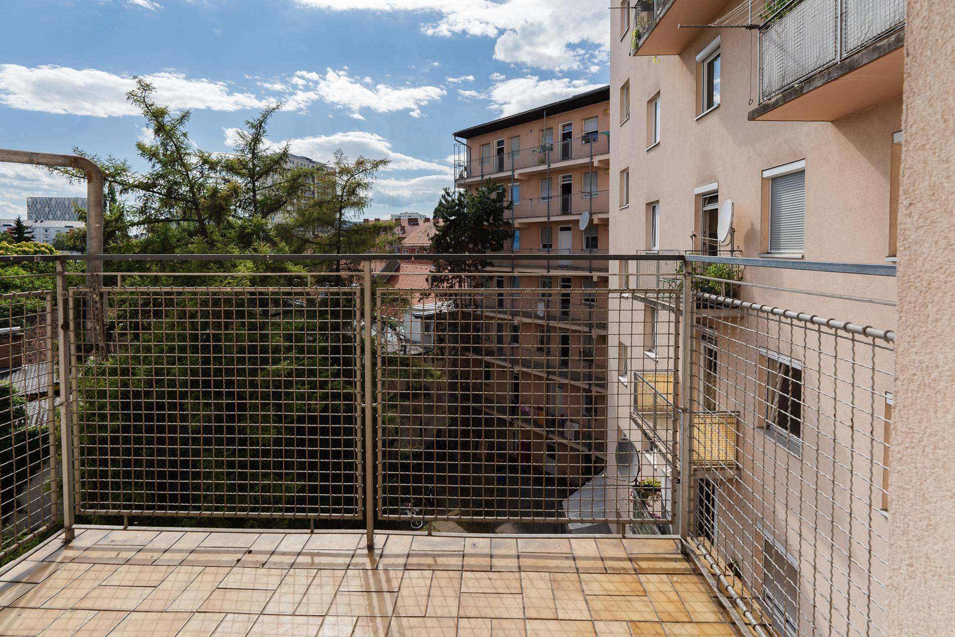 Geräumiger Balkon mit Fliesenboden und weitem Blick auf die Nachbarschaft.