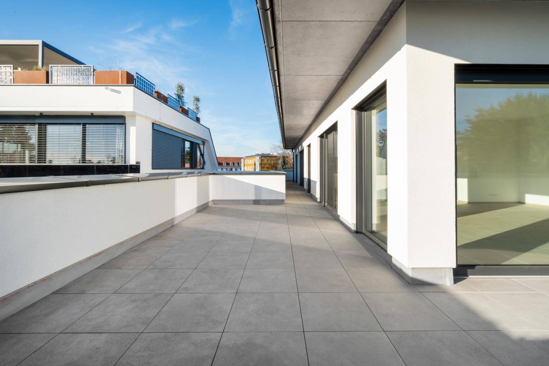 Lange Dachterrasse mit moderner Gestaltung und Blick auf die umliegenden Gebäude.