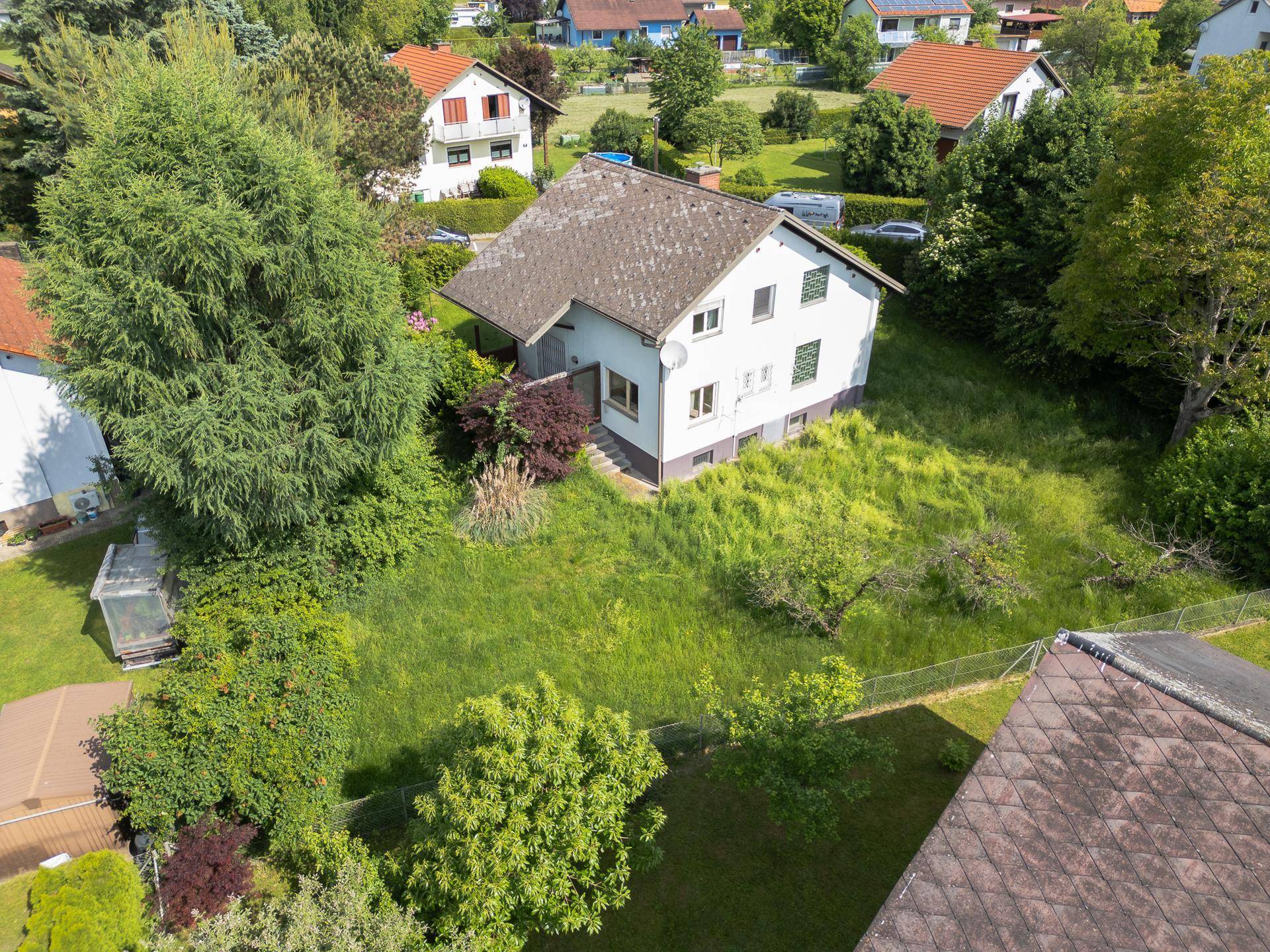 Luftaufnahme des Hauses mit weitläufigem Garten und Blick auf die umliegende Wohngegend.