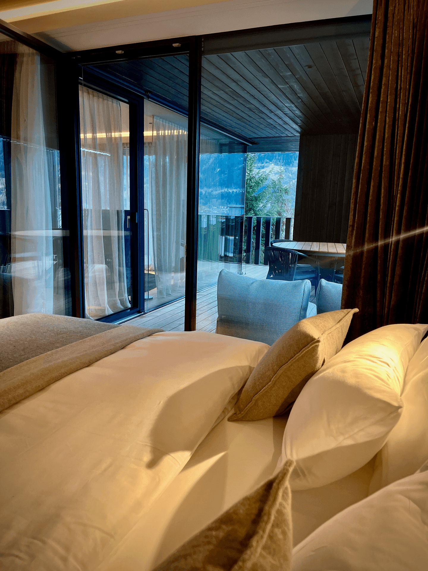 Schlafzimmer mit Zugang zu einem Balkon und Blick auf die umliegende Berglandschaft.