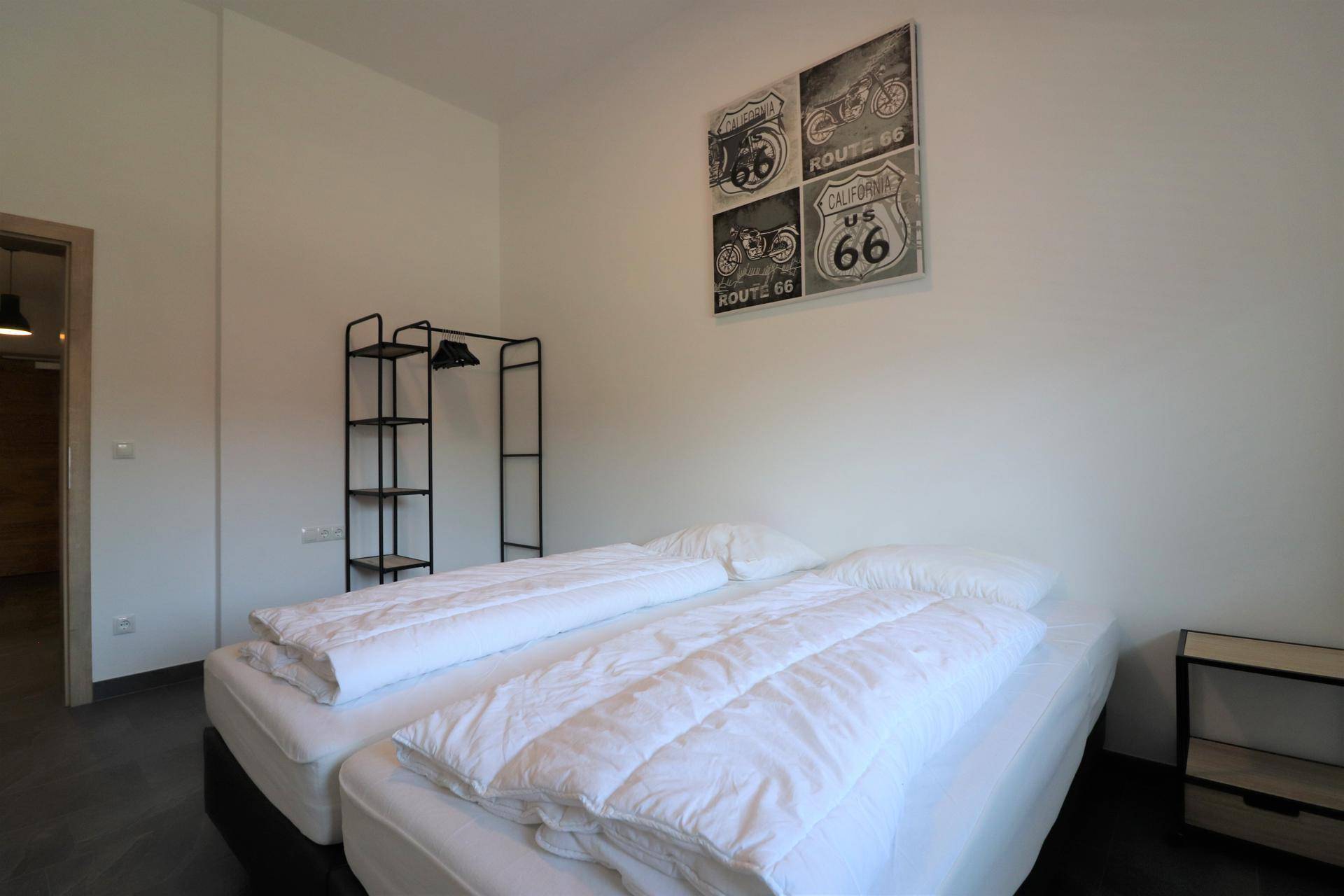 Schlafzimmer mit zwei Einzelbetten, schlichter Einrichtung und Wanddekoration.