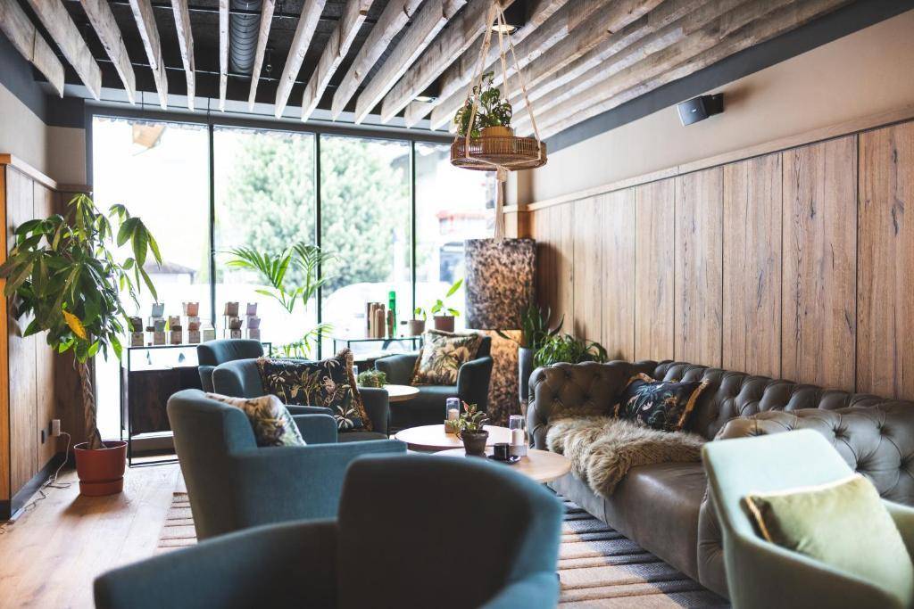 Gemütliche Lounge mit Holzwänden, bequemen Sofas und großen Fenstern.