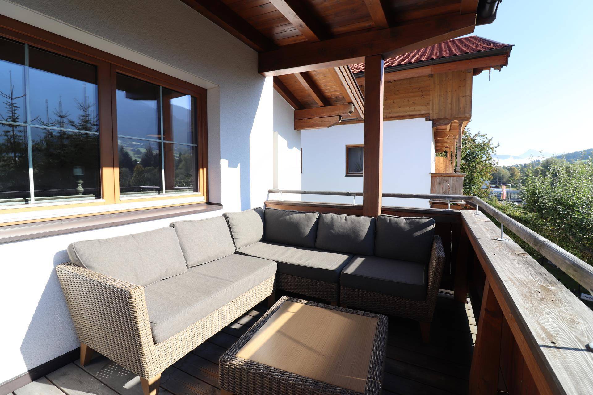 Gemütlicher Balkon mit bequemen Loungemöbeln und weitreichendem Blick auf die Berge.