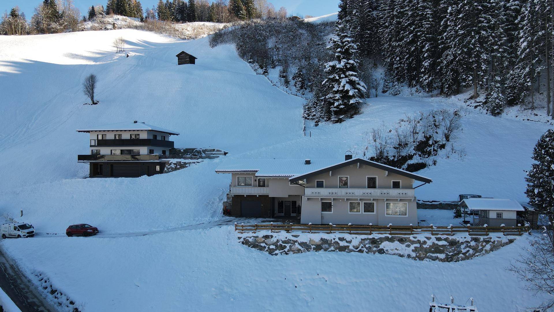 Panoramablick auf das Haus und die verschneite Berglandschaft mit weiteren Gebäuden.