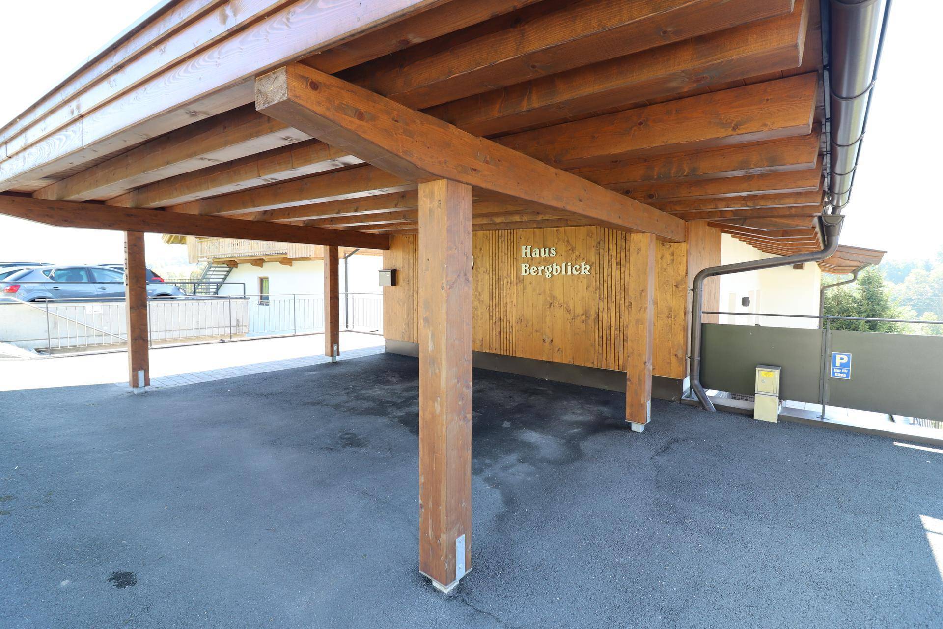 Überdachter Carport mit Holzbalken und ausreichend Platz für Fahrzeuge.