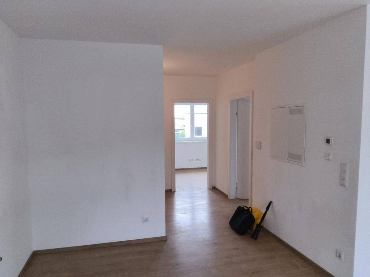 Geräumiger Flur mit Laminatboden, der zu weiteren hellen Zimmern führt.