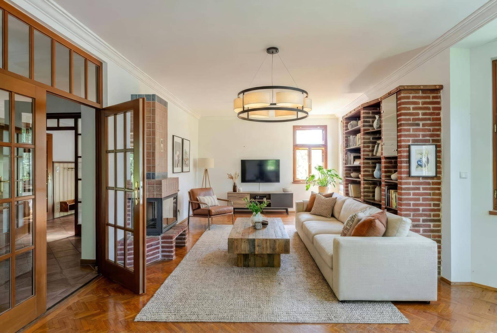 Gemütliches Wohnzimmer mit Kamin, Parkettboden und bequemen Sofas, hell und einladend.