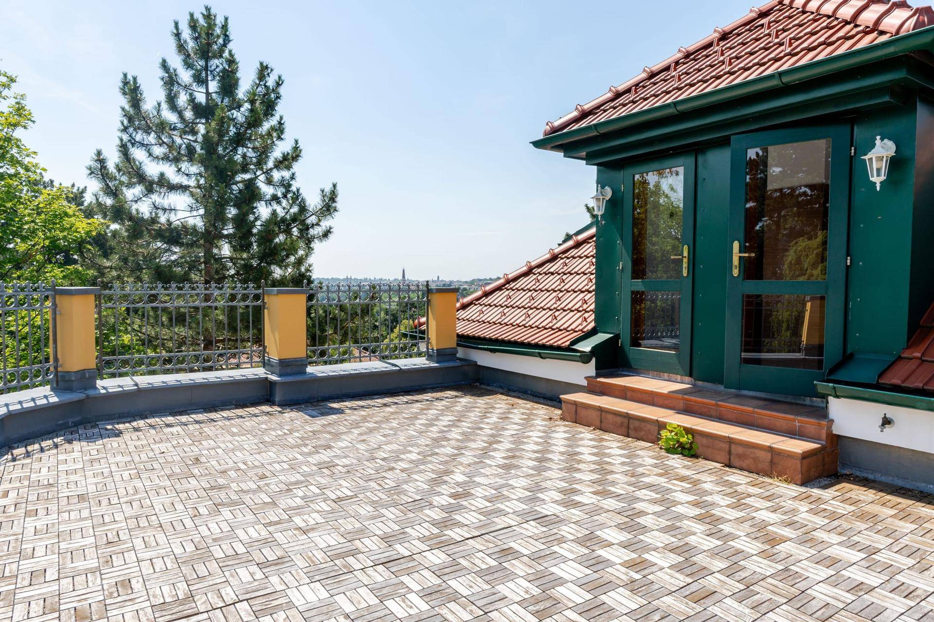 Große Dachterrasse mit Holzbodenfliesen und weitem Blick über die Umgebung.