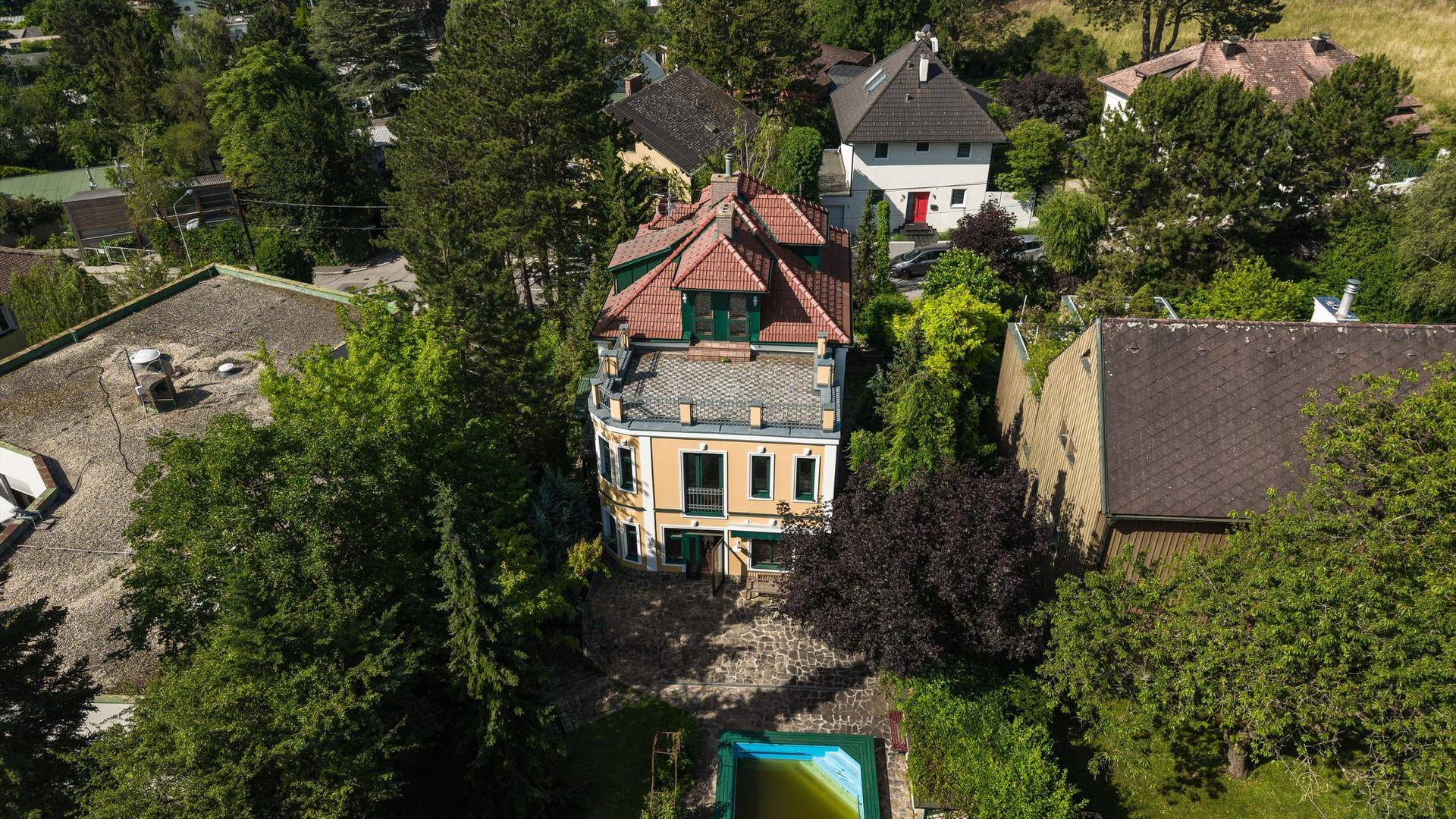 Weitläufige Luftaufnahme der Villa mit Pool und umliegender grüner Landschaft.