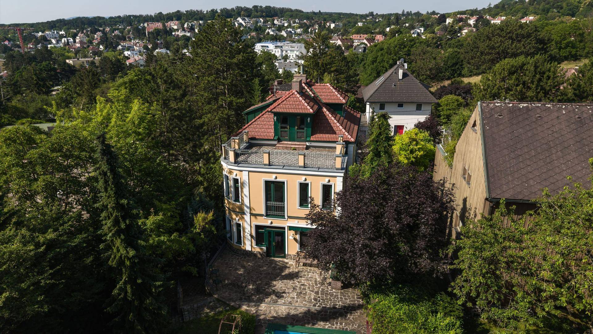 Panoramische Luftaufnahme der Villa mit rotem Dach und üppigem Grün in der Umgebung.