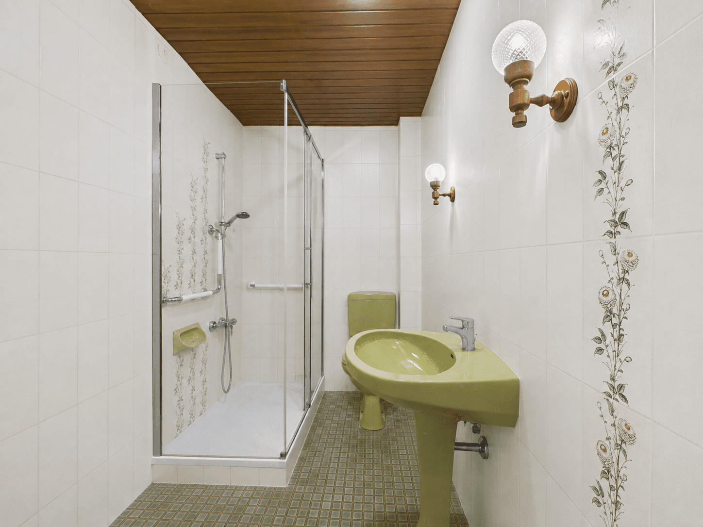 Badezimmer im Stil der 80er Jahre mit grünen Sanitärobjekten, Dusche und Holzdecke.