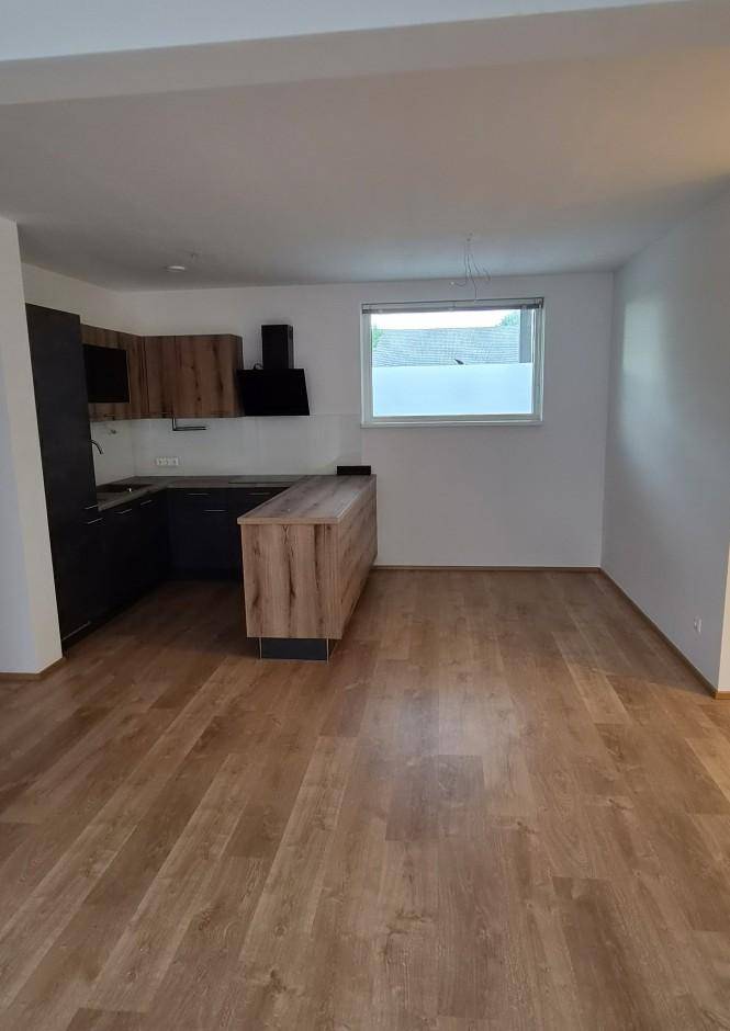 Moderne Wohnküche mit Holzlaminatboden, dunklen Schränken und einer Kücheninsel.