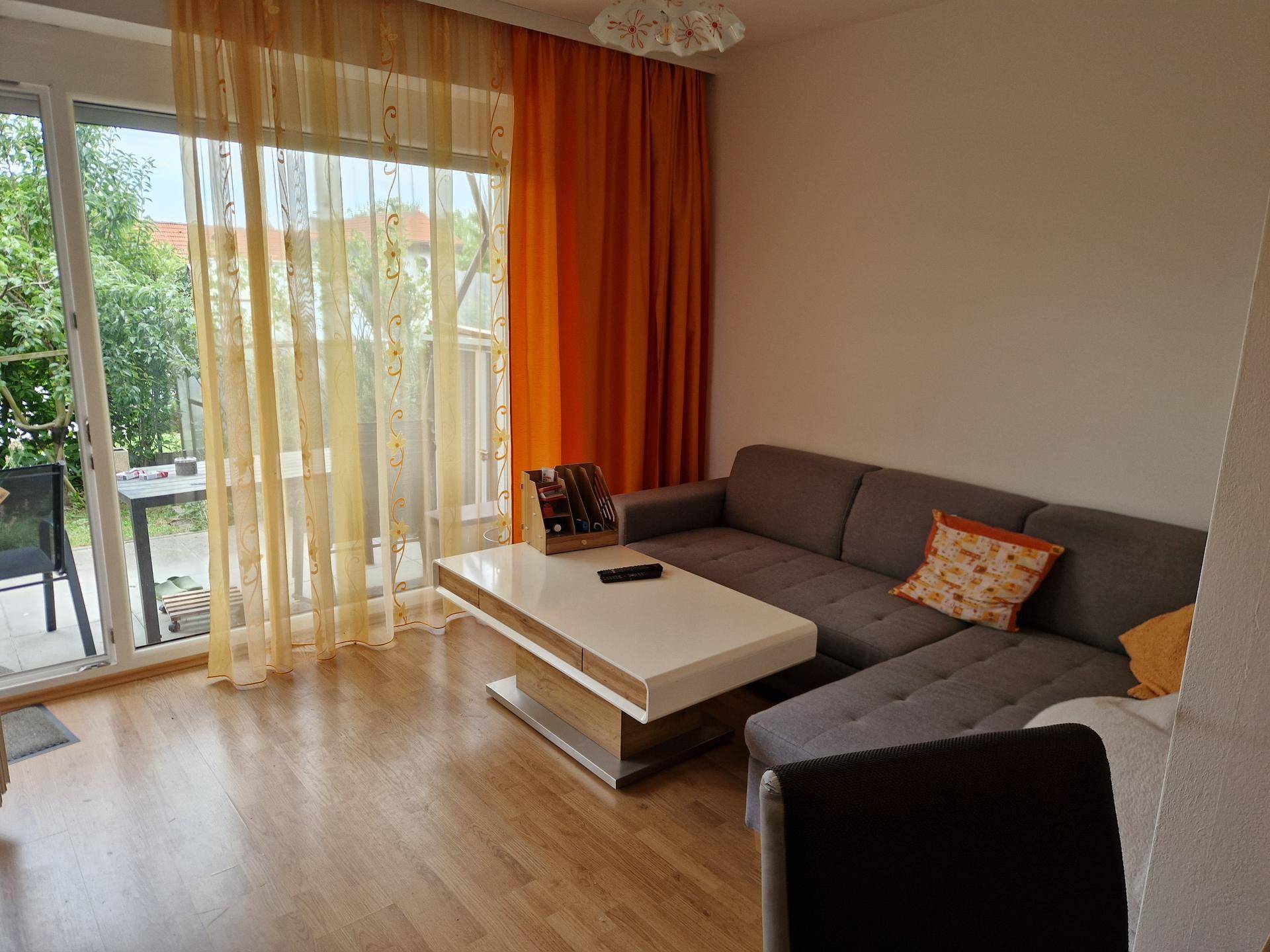 Helles Wohnzimmer mit Sofa, Couchtisch und direktem Zugang zur Terrasse.