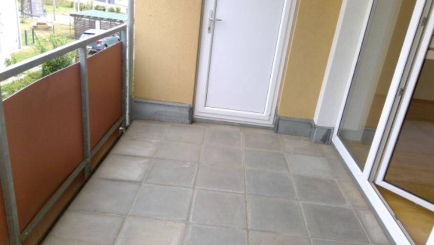 Gefliester Balkon mit Metallgeländer und Blick auf die Umgebung.
