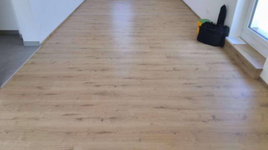 Heller Raum mit neu verlegtem Laminatboden, bereit zur Einrichtung.