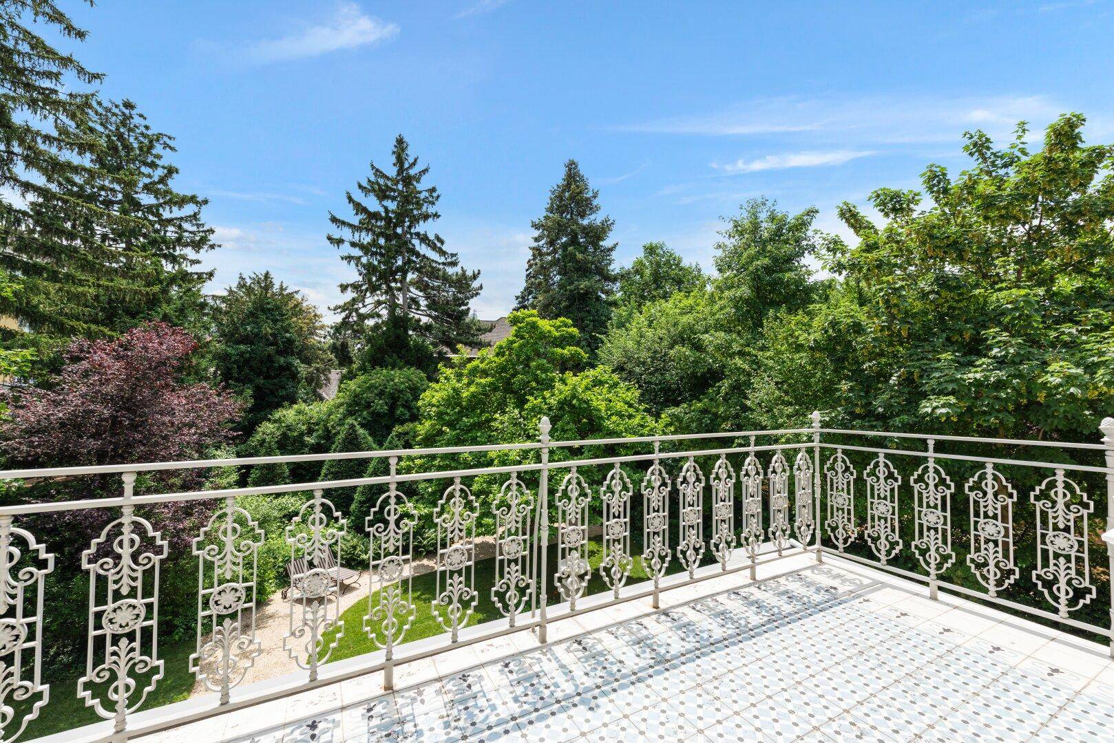 Geräumiger Balkon mit schmiedeeisernem Geländer und weitem Blick ins Grüne.