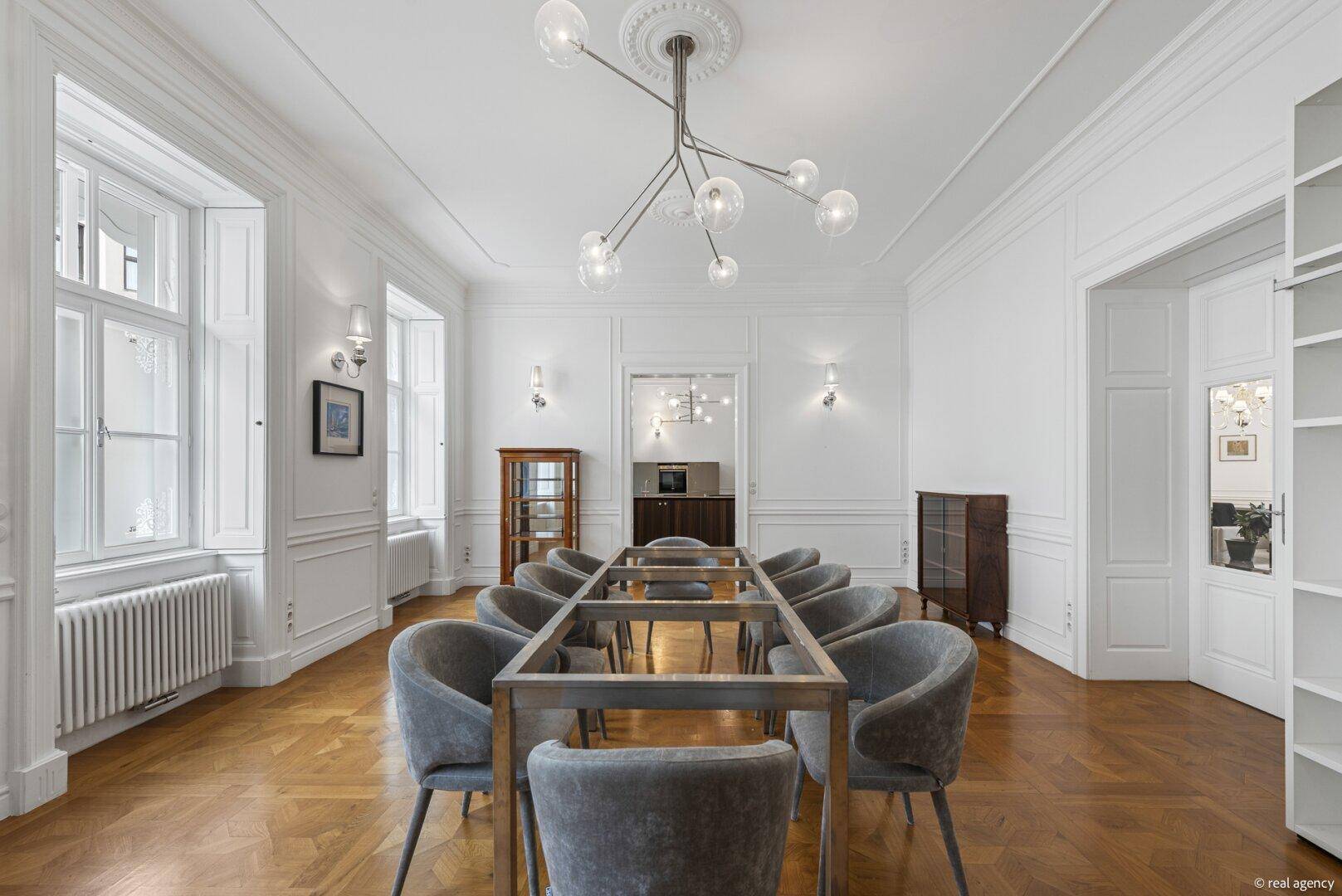 Eleganter Essbereich mit langem Tisch, modernen Stühlen und stilvoller Beleuchtung.