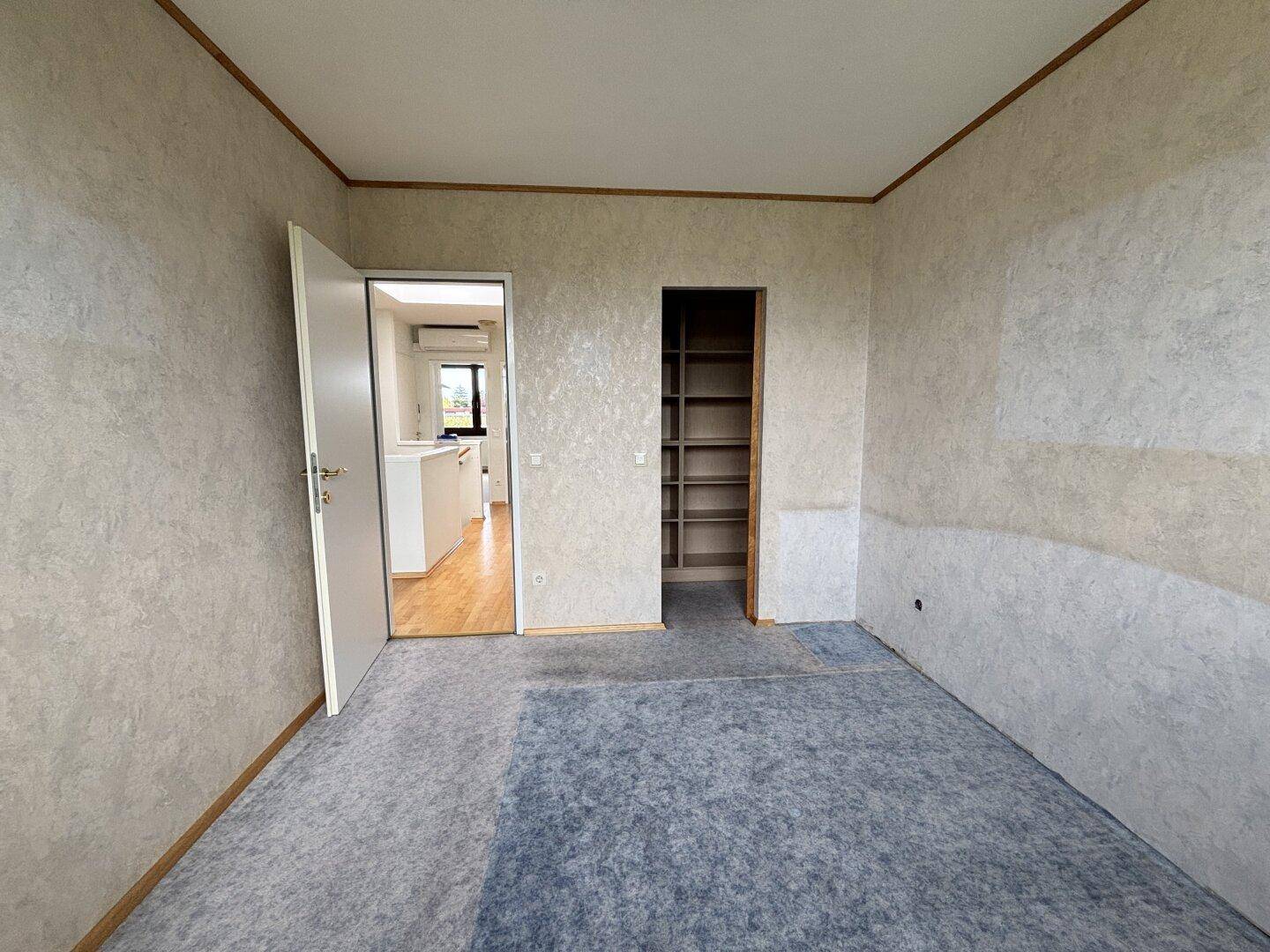 Weiteres Schlafzimmer mit Teppichboden und Zugang zu einem Einbauschrank.