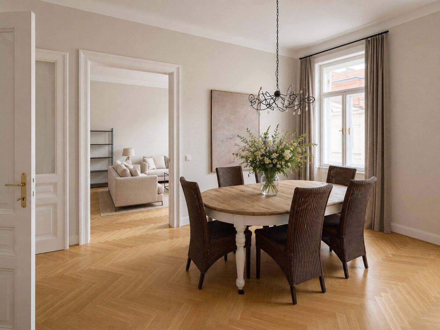 Eleganter Essbereich mit rundem Holztisch, Korbstühlen und Parkettboden.