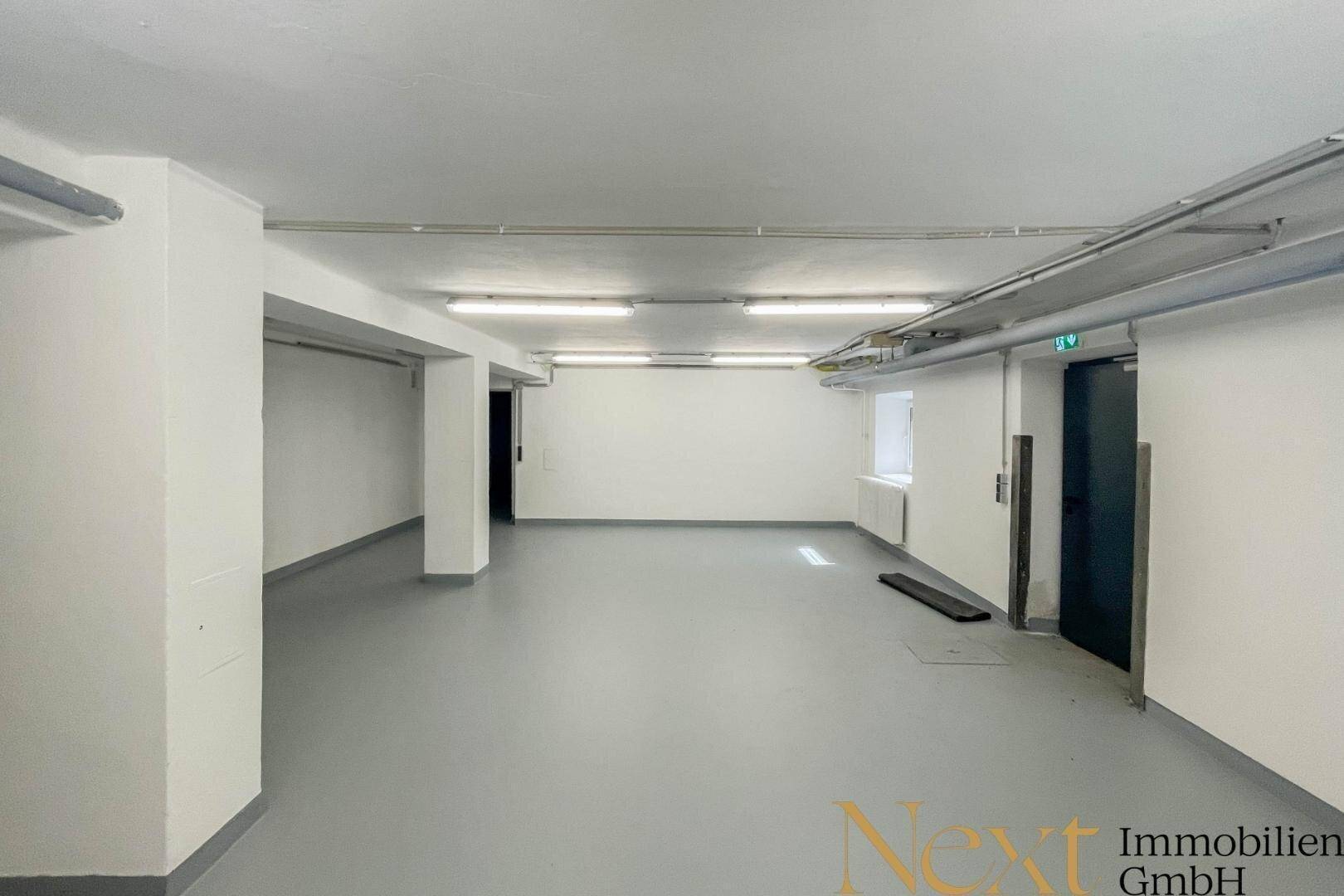 Geräumiger Kellerraum mit hellem Boden und guter Beleuchtung, ideal als Lagerfläche nutzbar.