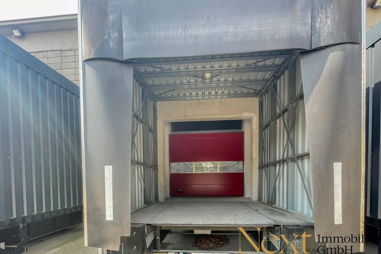 Nahaufnahme einer Laderampe mit rotem Tor, bereit für die Beladung und Entladung von LKWs.