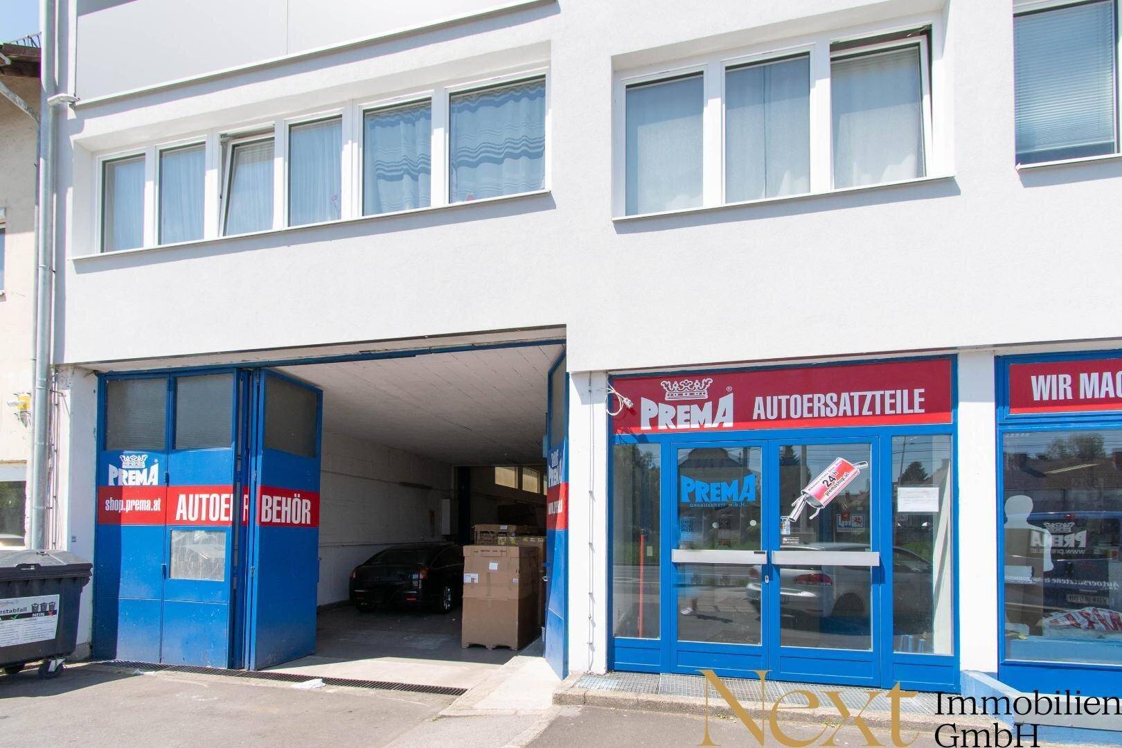 Erdgeschoss eines Geschäftsgebäudes mit großem Garagentor und Einzelhandelsflächen.