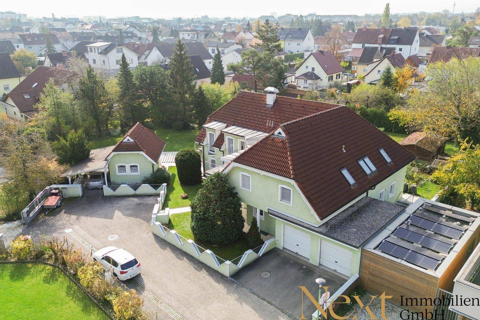 Luftaufnahme des Anwesens mit Haupthaus, Garage und Photovoltaikanlage auf dem Dach.