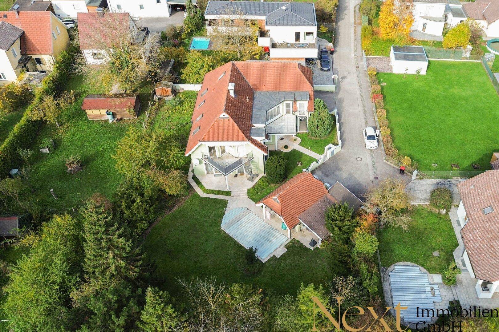 Luftaufnahme des Anwesens mit Haupthaus, Nebengebäude und großem Garten in ländlicher Umgebung.