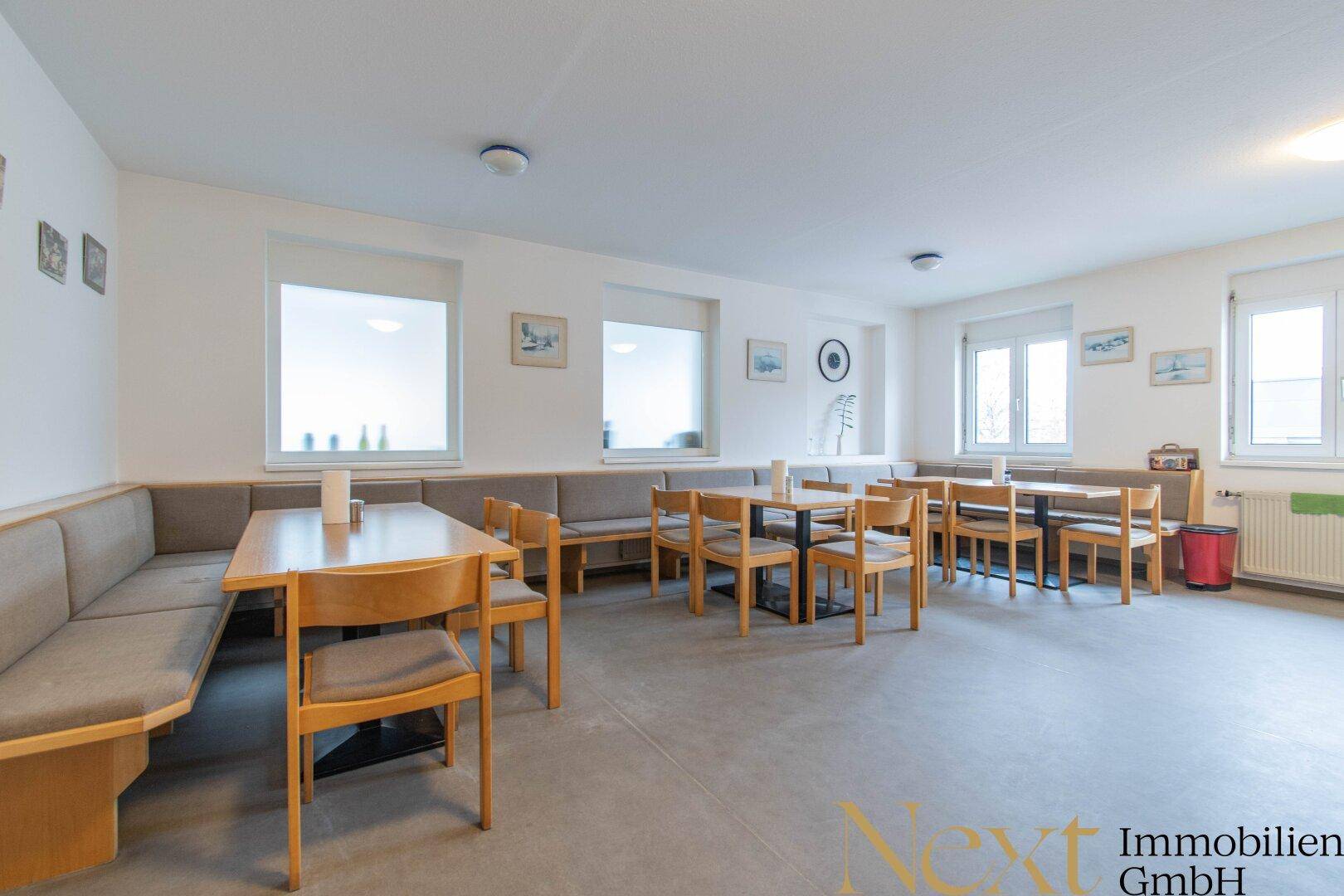 Geräumige Kantine mit mehreren Tischen und Bänken, ideal für Pausen und Mahlzeiten der Mitarbeiter.