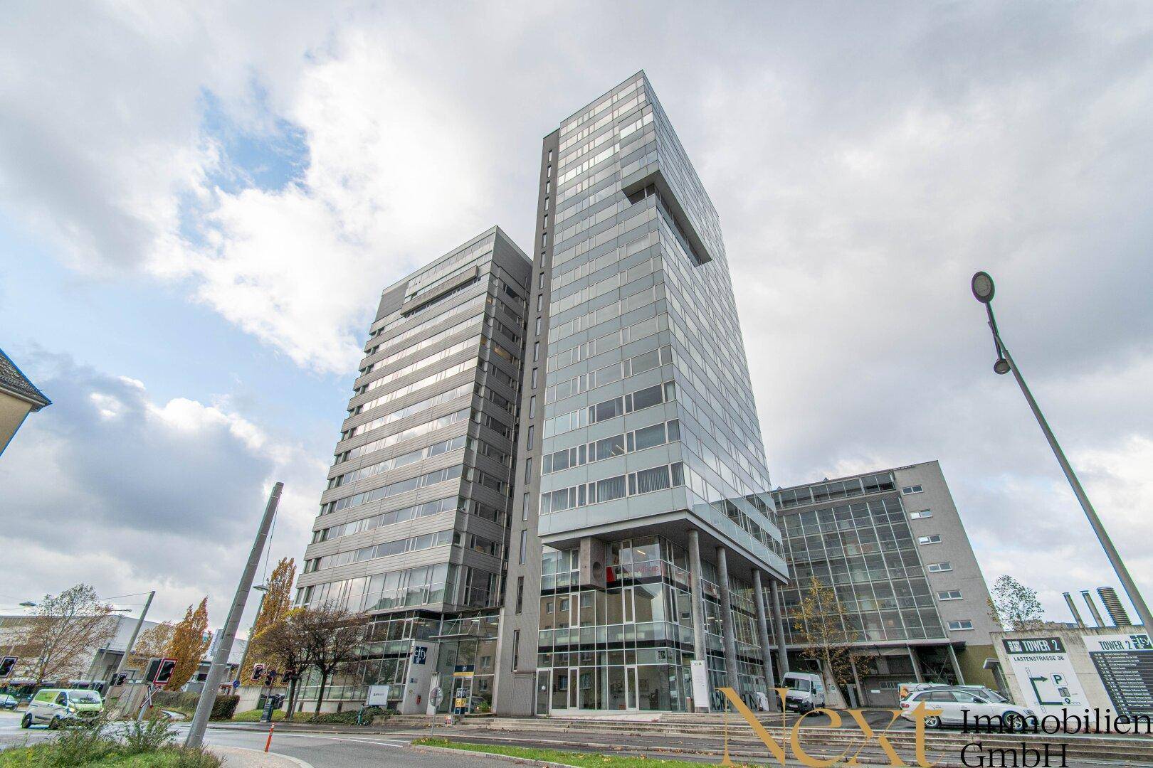 Modernes Hochhaus mit markanter Glasfassade und zeitgenössischer Architektur an einer städtischen Straße.