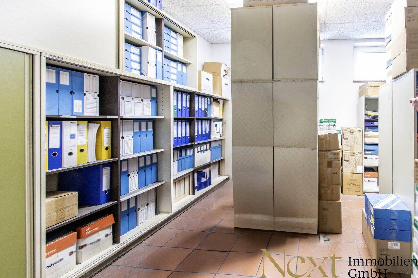 Archivraum mit hohen Regalen voller Aktenordner und Lagerboxen, ideal für Dokumentenlagerung.