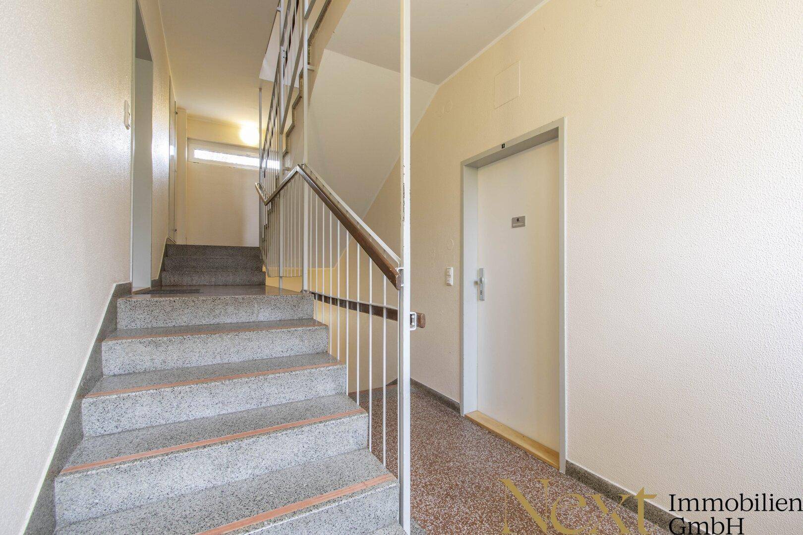 Treppenhaus mit Steinstufen und Zugang zu den Wohneinheiten.