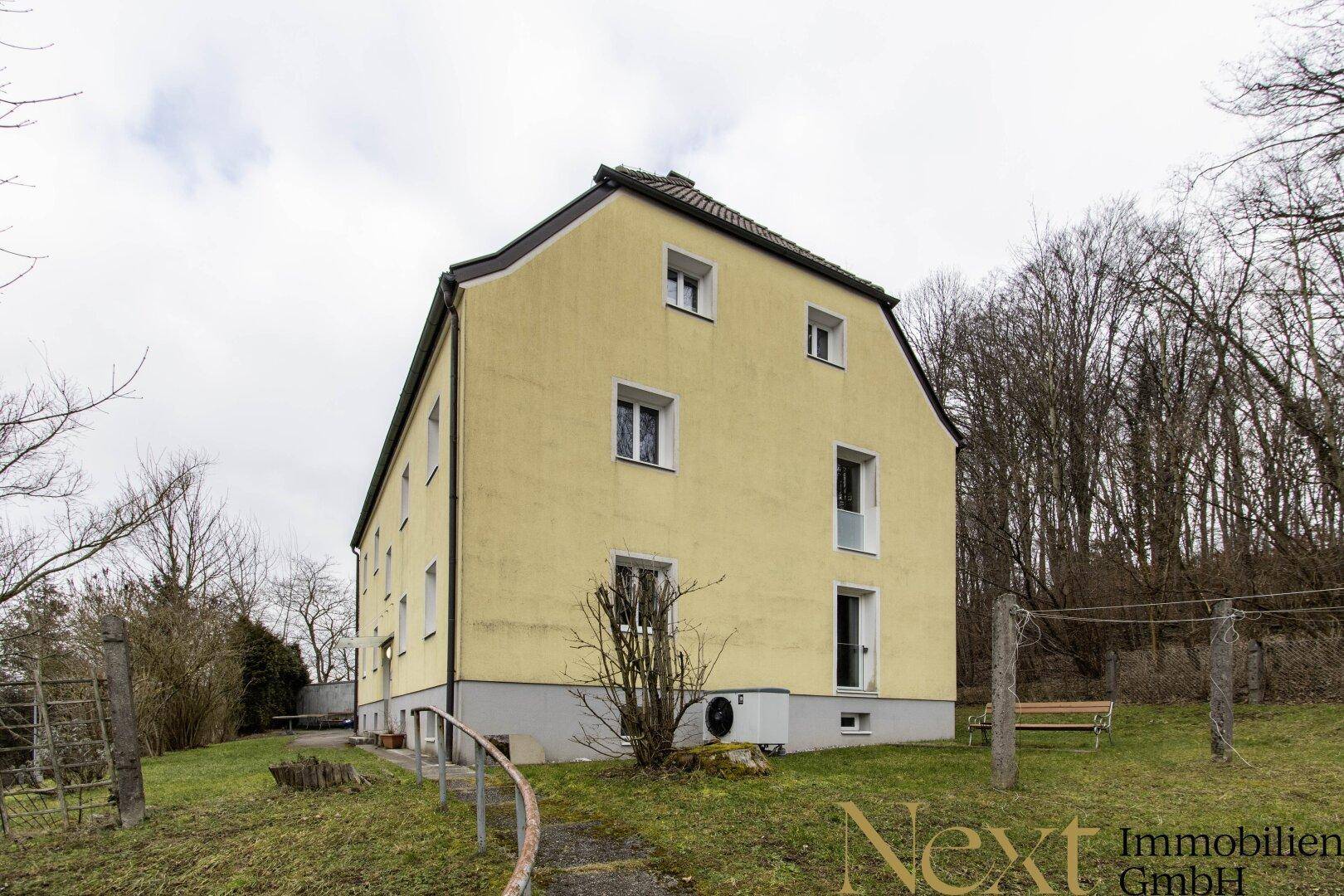Rückseite des Gebäudes mit Gartenbereich und Wäscheleinen im Winter.