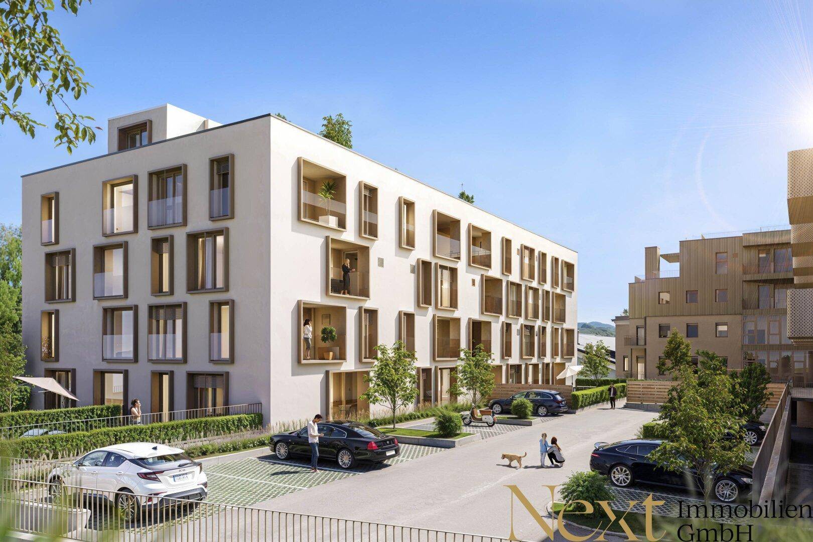 Moderne Wohnanlage mit markanter Fassade, großen Fenstern und Außenparkplätzen.