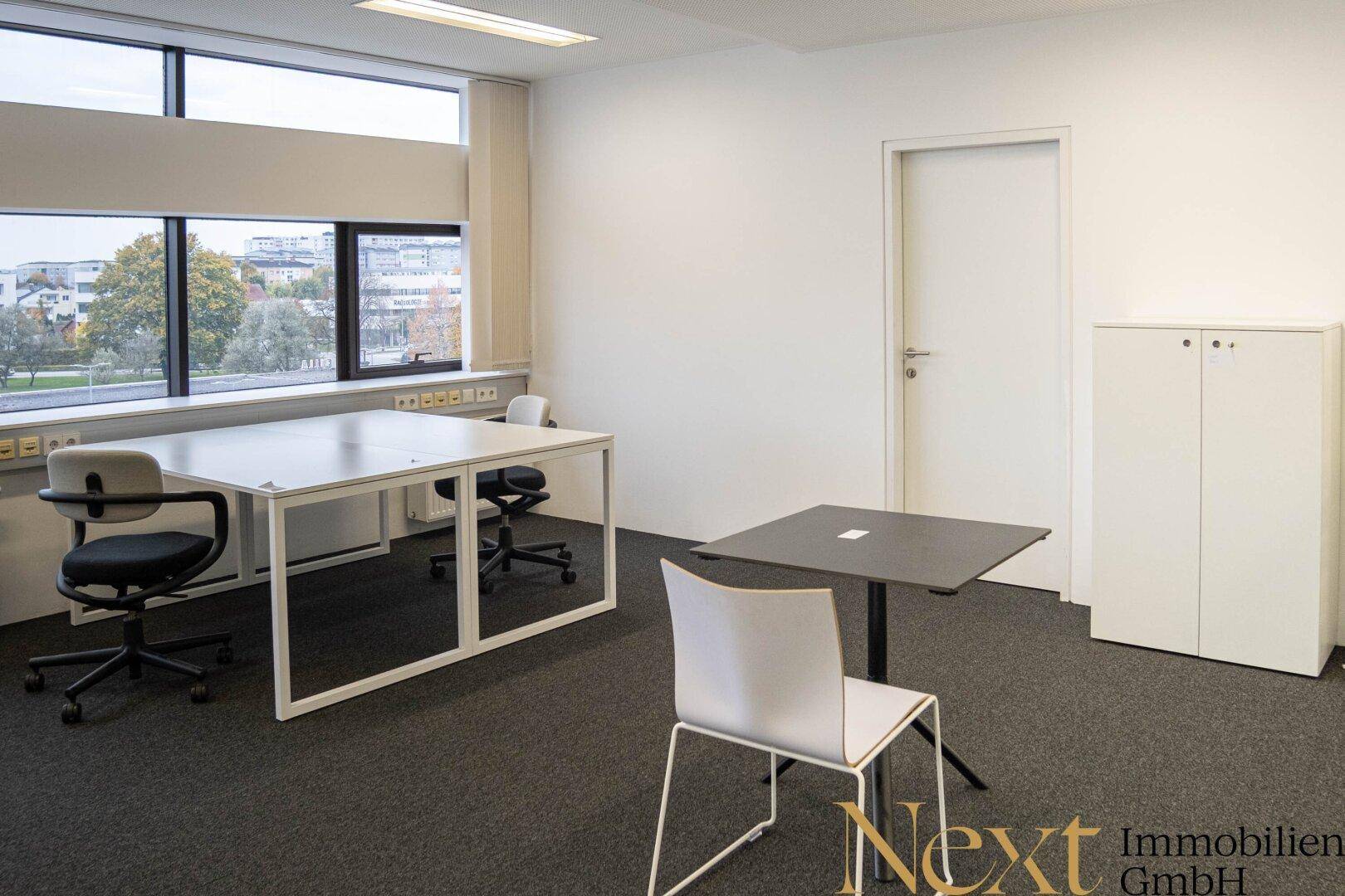 Flexibler Bürobereich mit Schreibtisch, kleinem Beistelltisch und Stauraum, ideal für verschiedene Arbeitsstile und Bedürfnisse.