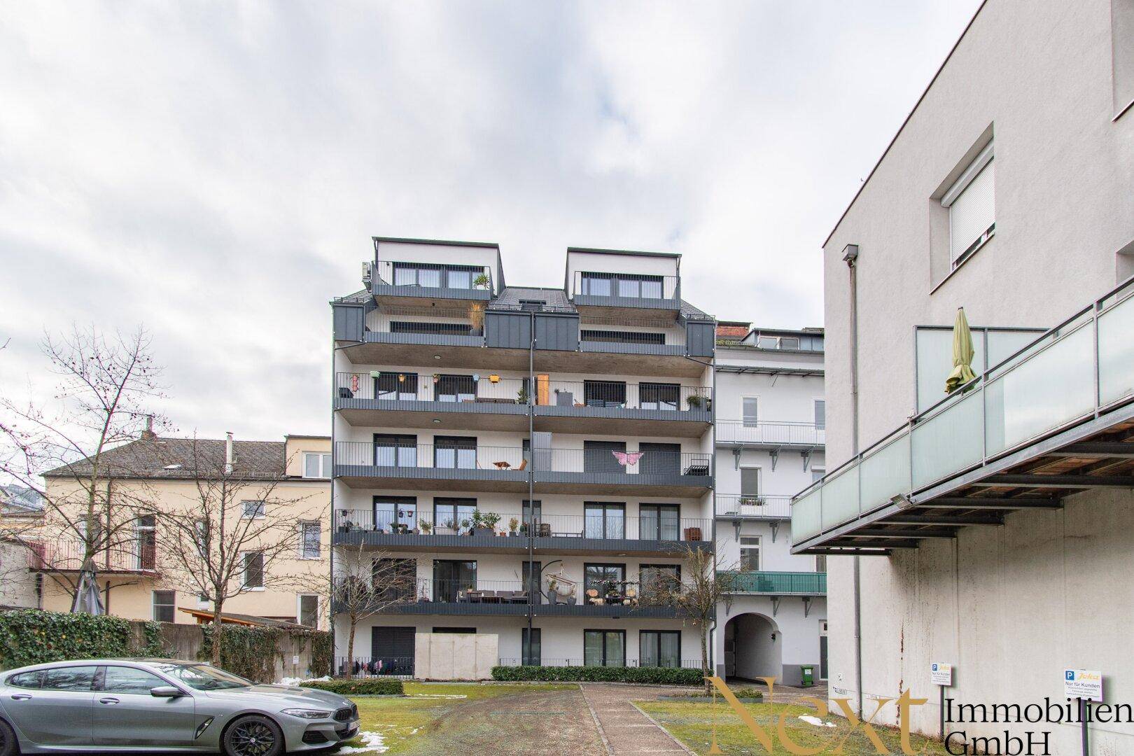Moderne Wohnanlage mit mehreren Balkonen und gepflegter Außenanlage.