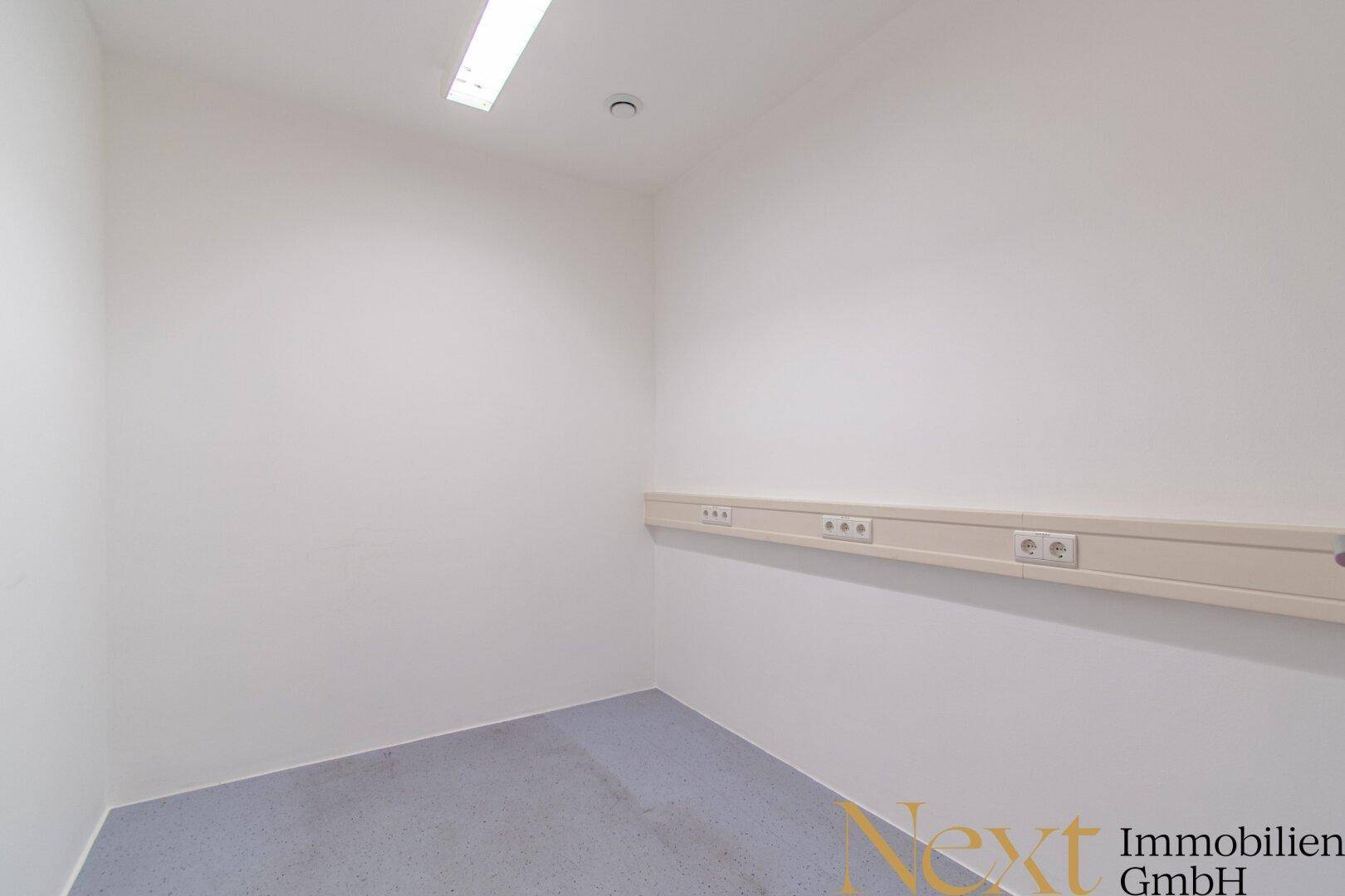 Kleiner Raum mit Steckdosenleiste an der Wand und einfacher Beleuchtung.