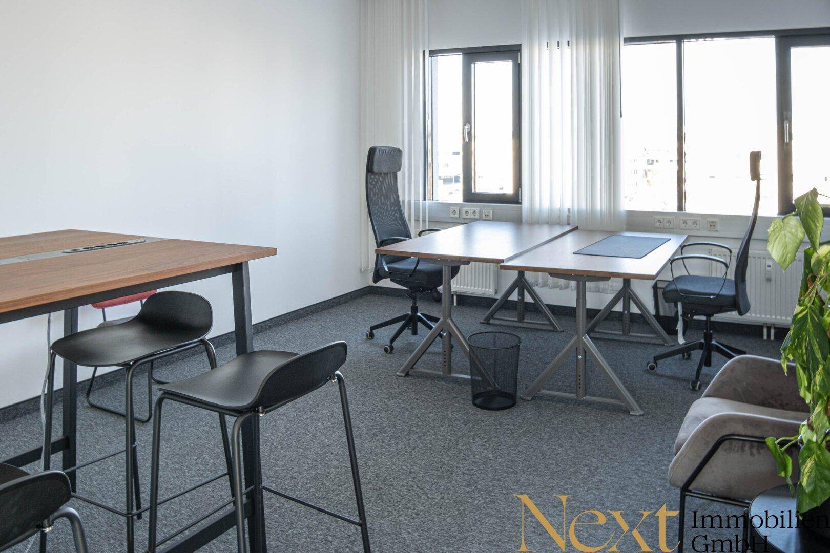 Helles Büro mit modernen Schreibtischen, ergonomischen Stühlen und Teppichboden, ideal für Teamarbeit.
