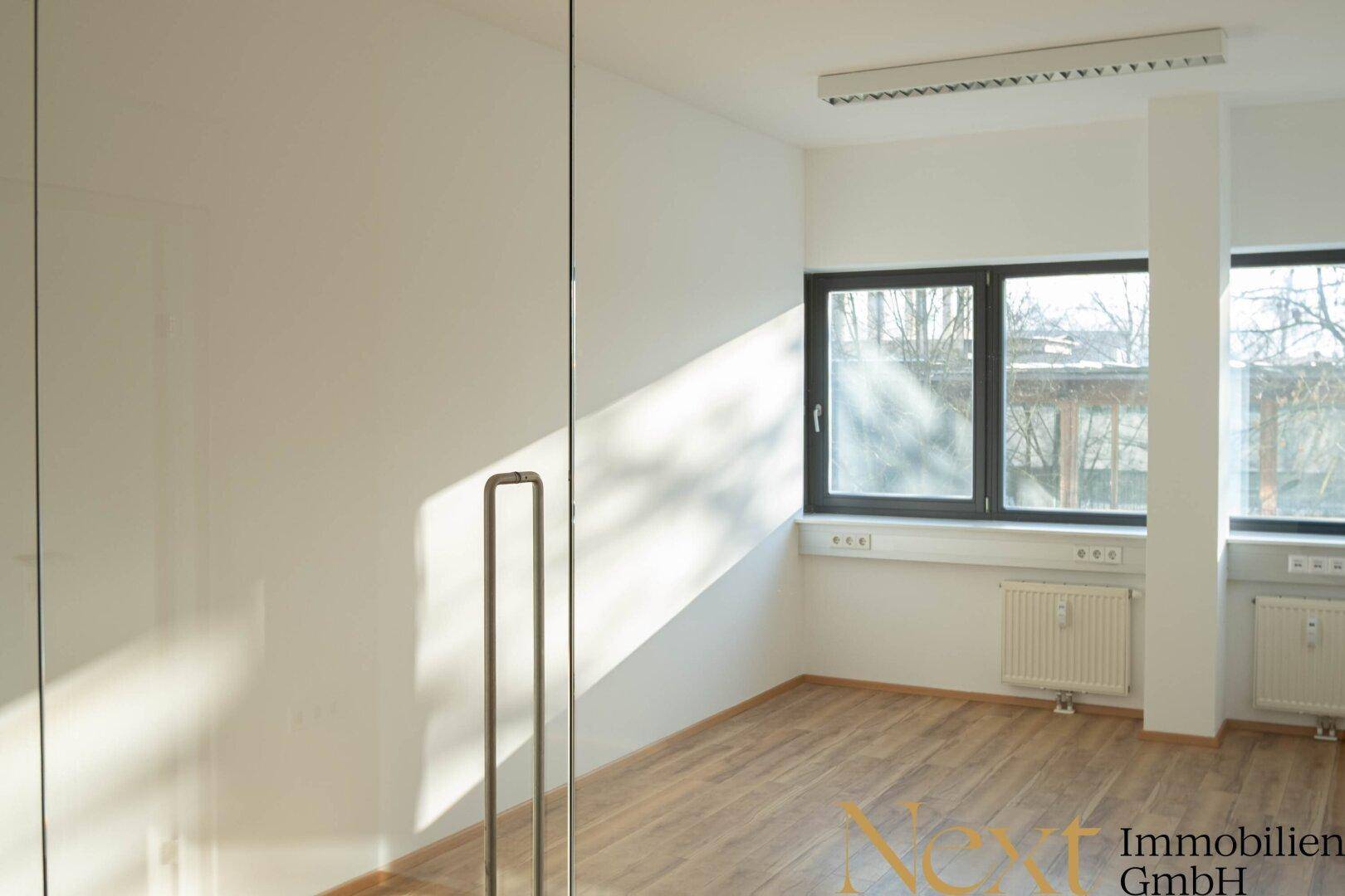 Helles Eckbüro mit großen Fenstern, Holzboden und Heizkörpern, ideal für produktives Arbeiten.